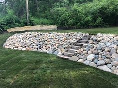 there is a rock garden in the middle of the grass and rocks on the ground