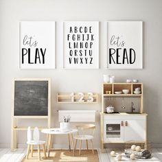 three black and white posters on the wall above a small table with chairs in front of it