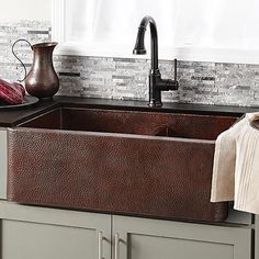 a kitchen sink that is brown and has some dishes on the counter next to it