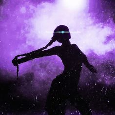 the silhouette of a person wearing a helmet and holding an object in one hand while standing on snow covered ground