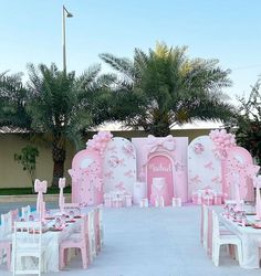 a pink and white wedding set up with chairs