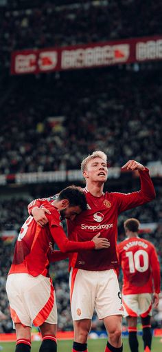 two soccer players are hugging each other on the field