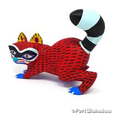 a red and black cat figurine sitting on its back with it's legs spread out