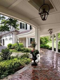 the front porch is covered with white pillars and columns, along with brick walkways