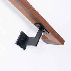 a close up of a metal and wood object on a white wall with a wooden handle