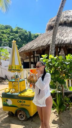 a woman standing in front of a yellow cart with food on it's side