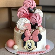 a mickey mouse cake with pink and white frosting