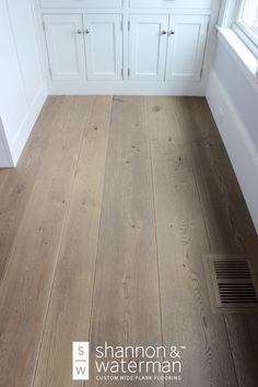 a wood floor in a kitchen with white cabinets