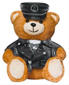 a brown teddy bear wearing a leather jacket and hat sitting in front of a white background