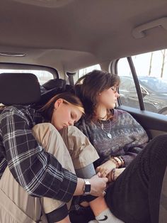 two people sitting in the back seat of a car