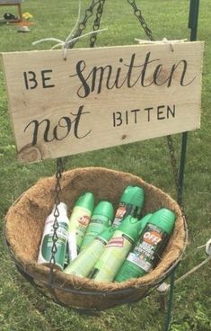 a sign that says be smitten not bitten in front of some green bottles