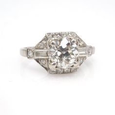 A perfect Art Deco engagement ring. A 1.75 ct Old European Cut diamond (G VS2) is flanked on either side by a baguette diamond (0.14 ct total, F VS1). The entire ring is outlined by 0.30ct of F VS2 round diamonds, bringing the total carat weight to 2.19 ct. The ring is made of platinum.We must say, it is rare to find a high color, high clarity stone and have it be an old fashioned cut. When the modern brilliant first arrived, a lot of people took their good diamonds and had them recut in an effo Art Deco Jewelry 1920s, Wedding Watches, Rough Gemstone Jewelry, Always A Bridesmaid, Art Deco Engagement, Engagement Rings Round, Deco Engagement Ring, Ideal Wedding, Deco Ring