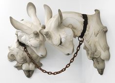 two white rhino heads with chains attached to them