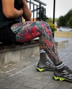 a man with tattoos sitting on a bench next to his legs and leggings