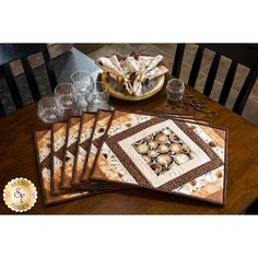 a wooden table topped with place mats and wine glasses