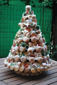 a christmas tree made out of wine corks on a wooden table in front of a green wall