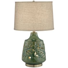 a green table lamp with a beige shade