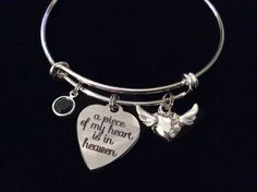 a silver bracelet with a heart and two charms on it that says, a piece of my heart is in heaven