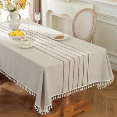 a dining room table with two plates of food on it and flowers in the vase