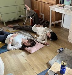 three women are laying on the floor in their living room