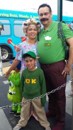 a man, woman and child are standing in front of a bus with costumes on