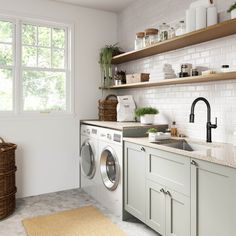 a washer and dryer in a kitchen with open shelving above the sink