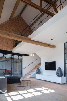 an open living room with wooden floors and white walls, large windows on the wall