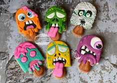 five decorated cookies with faces and mouths on top of each other, one is biting the other's tongue