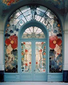 a blue door with stained glass and flowers on it