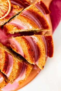 slices of orange and blood orange cake on a white plate with pink glazes