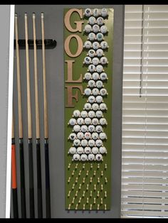 a golf themed wall hanging next to some cues and ball markers with the word golf spelled on it