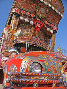 an elaborately painted truck is parked on the side of the road in front of a blue sky