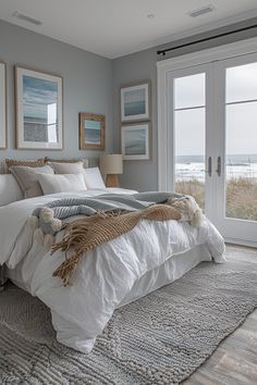 a bedroom with a large bed and two doors leading to the outside patio area that overlooks the beach