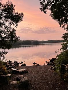 a lake with rocks and trees around it