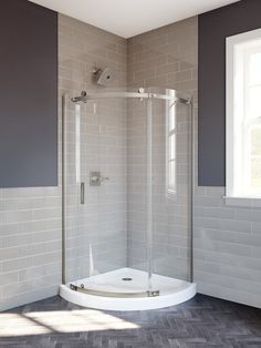 a corner shower stall in a bathroom with grey walls and wood flooring, along with white tiles