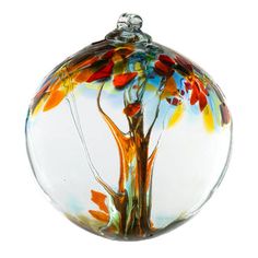 a glass ornament with a tree on it