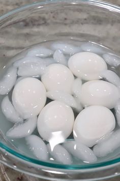 some white eggs are in a glass bowl