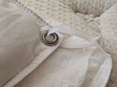 a close up of a white pillow with a ring on the back of it's cover