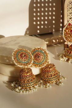 Embrace the elegance and artistry with the beautiful Samreen Jhumka Earrings. Crafted from high-quality brass and adorned with soft colors, these jhumka earrings are designed to make you stand out. Featuring multicolor navratan stones and gold plating with zircon stones, these 3-inch earrings are both chic and statement-making. These elegant jhumka earrings are not just a piece of jewelry but a statement art. With a push pin back and earring support backing, they ensure comfortable wear. Perfect