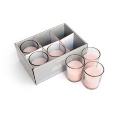 six pink candles are in a metal box