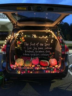 an open trunk of a car decorated with lights and fruit