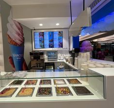 an ice cream shop with lots of desserts on display in front of the counter