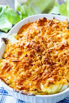 a casserole dish with meat and cheese in it on a blue checkered table cloth