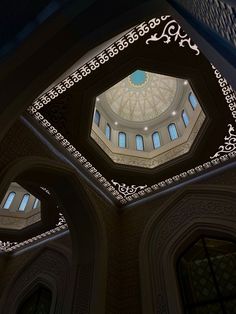 the inside of a building with three windows and a ceiling light in it's center