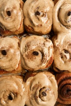 cinnamon buns with icing and chocolate chips arranged on a baking sheet, ready to be baked