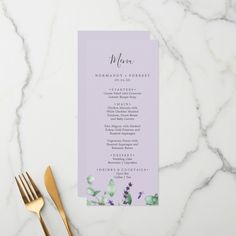 a purple menu card sitting on top of a table next to a fork and knife