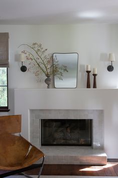 a living room with a fireplace and mirror above it