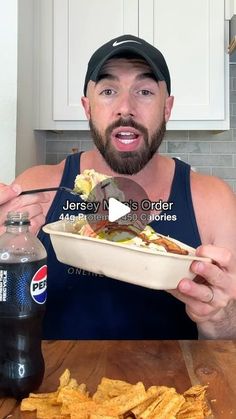 a man holding a bowl of food in front of his face while he eats it