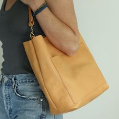 "This perfectly sized, perfectly casual beige leather shoulder bag will easily become your favorite everyday bag!  The front pocket keeps your cell phone handy, and the magnetic snap closure and inside slip pocket keep all your essentials secured inside. Handmade from luxurious vegetable tanned leather, and solid brass hardware, it will break in beautifully and age gracefully! This minimally dyed vegetable tanned leather is made in Italy from one of the world's finest tanneries, and will darken Age Gracefully, Minimalist Bag, Beige Bag, Simple Leather, Minimalist Wardrobe, Leather Hobo Bag, Break In, Day Bag, Personalize Bag