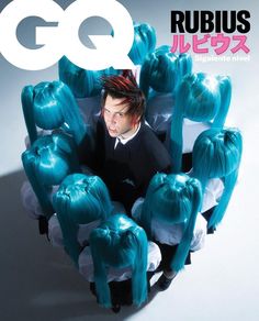 a man with blue hair sitting in a chair surrounded by wigs on the cover of gq magazine